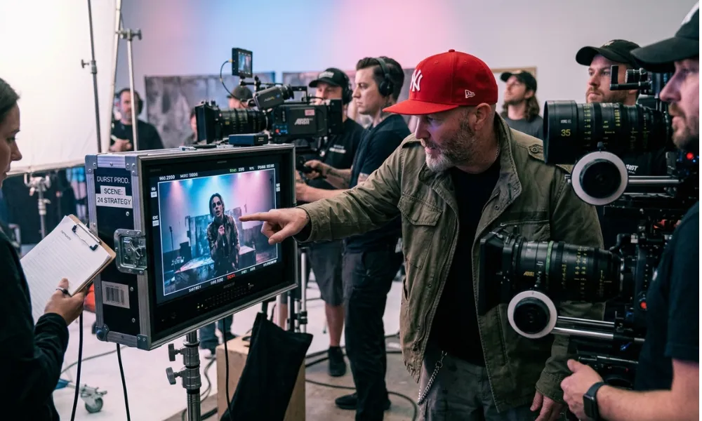 Facezem | Fred Durst Net Worth: How the Limp Bizkit Frontman Built His Fortune, Career and Legacy Fred Durst pointing at a video monitor while directing on a film set