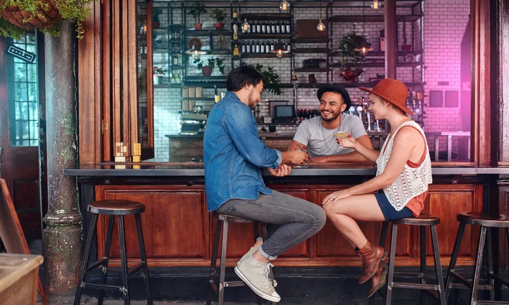 Friends hanging out and talking over drinks at a bar counter-Gen Z Slang