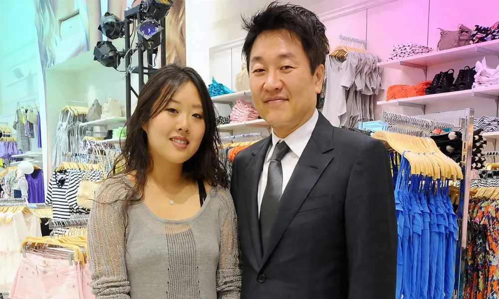 Do Won Chang and Jin Sook Chang standing inside one of their early clothing retail stores.