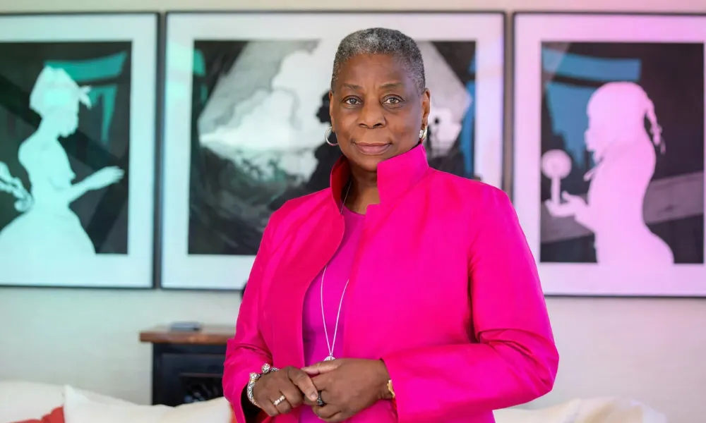 Ursula Burns standing in a room with modern art pieces on the wall.