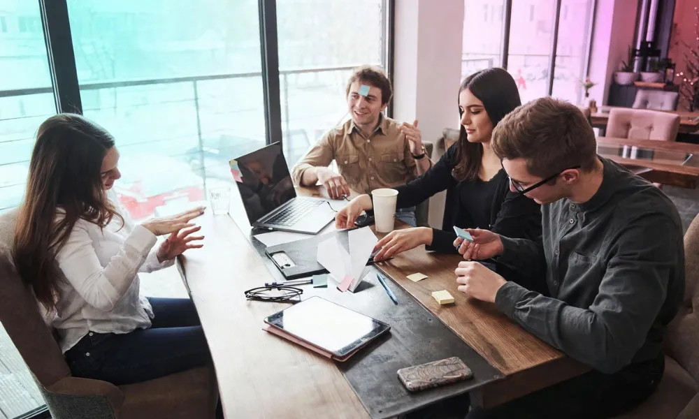 Colleagues collaborating and brainstorming around a meeting table in a modern office-Gen Z Slang